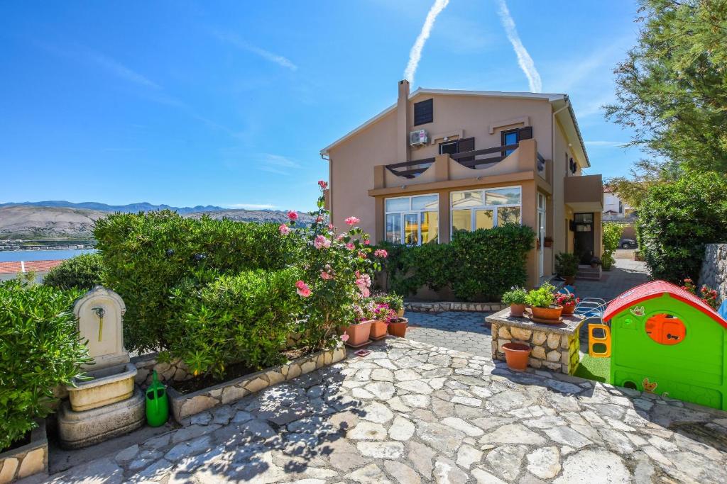 ein Haus mit einem Garten und einem Spielzeughaus in der Unterkunft Apartments Marija in Pag