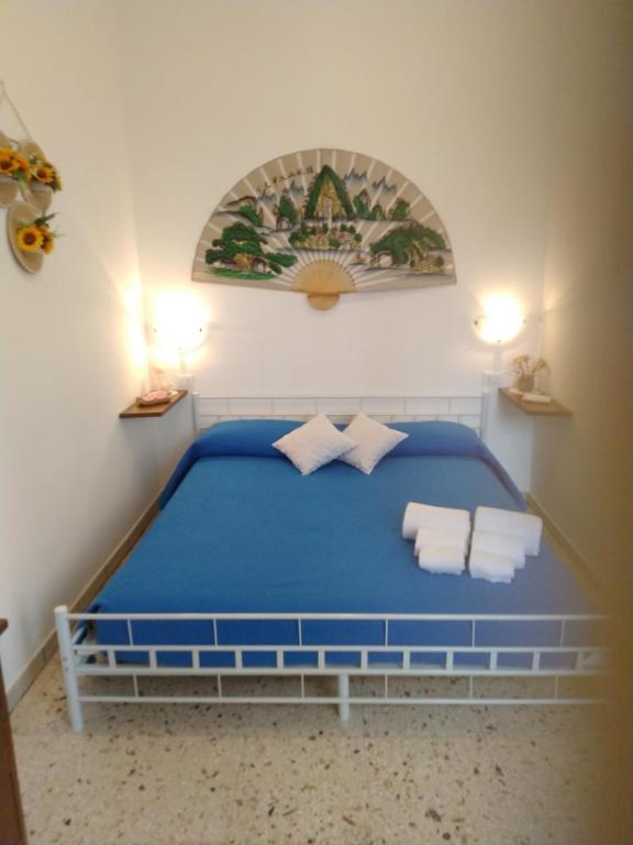 een slaapkamer met een blauw bed en handdoeken bij E case tu Bertu in Marina di Mancaversa
