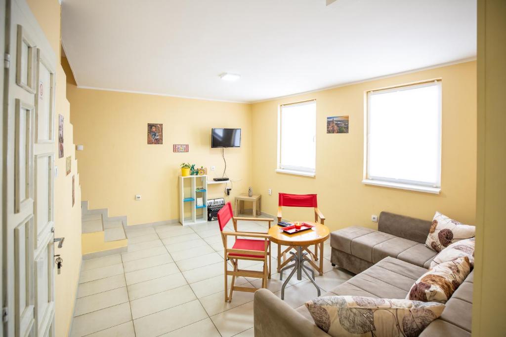 sala de estar con sofá y mesa en Passenger Hostel en Novi Sad