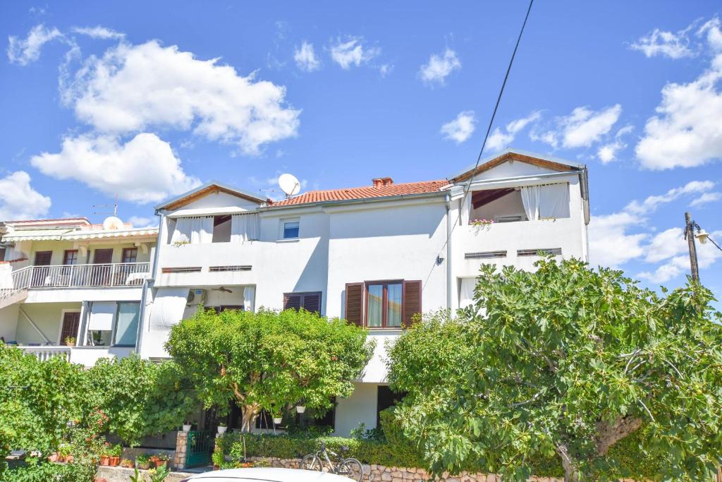 a white building with trees in front of it at Apartments Josip in Turanj