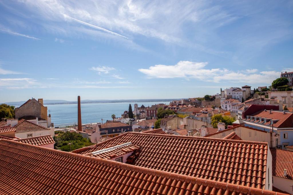 リスボンにあるAlfama Amazing Scenic River and City View Charming apartment With 2 bedrooms and AC 19th Century Buildingの赤い屋根と海の景色