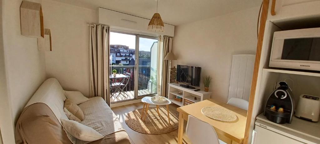a living room with a couch and a table and a window at T2 cosy/balcon sud ouest/300m-mer/Villers sur Mer in Villers-sur-Mer