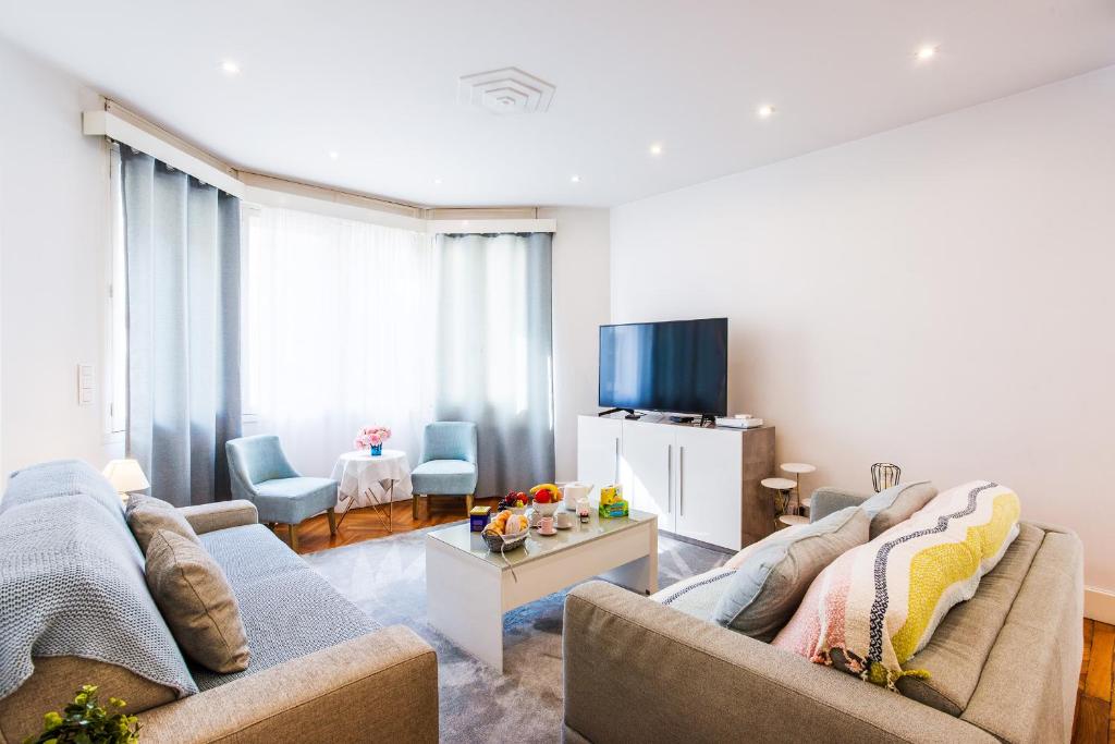 a living room with two couches and a tv at PALAIS PROMENADE AP4166 Nice, by Riviera Holiday Homes in Nice