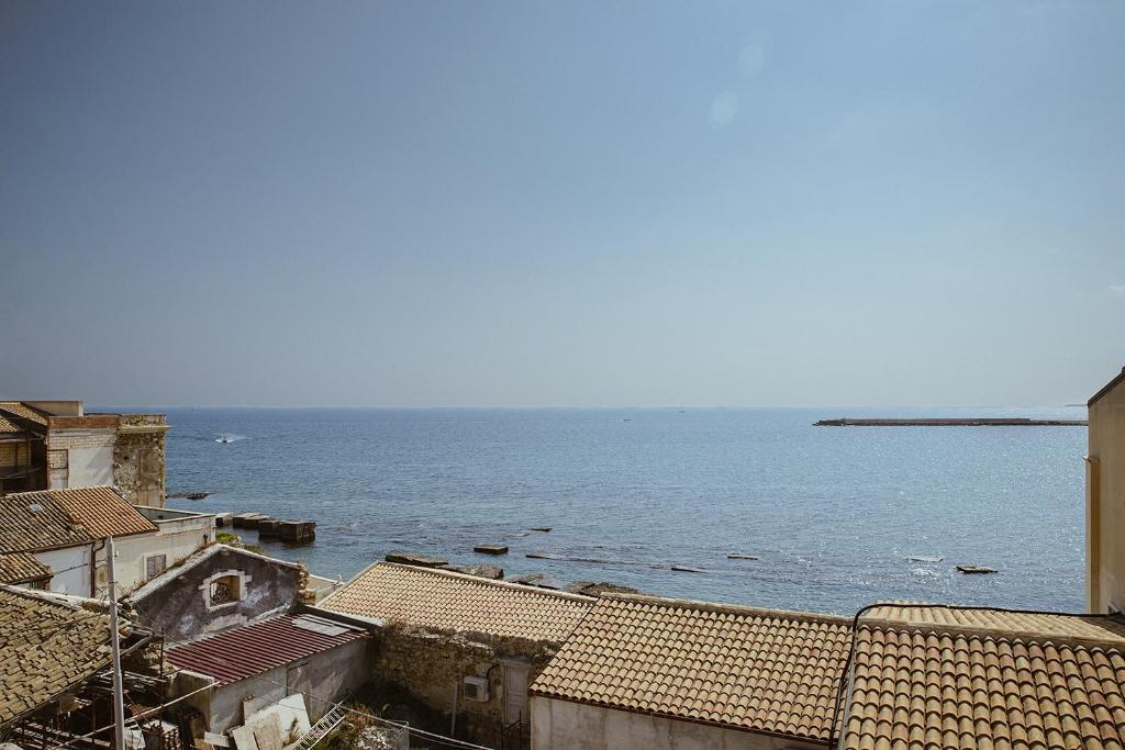 a view of the ocean from the roofs of buildings at Re Dionisio Apartments con terrazza by Wonderful Italy in Siracusa