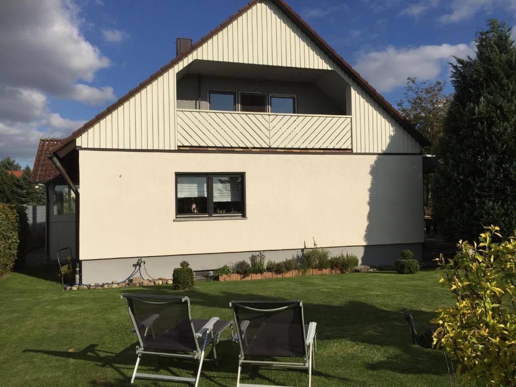 a house with two chairs in the yard at Ferienwohnung Wiesinger in Windelsbach