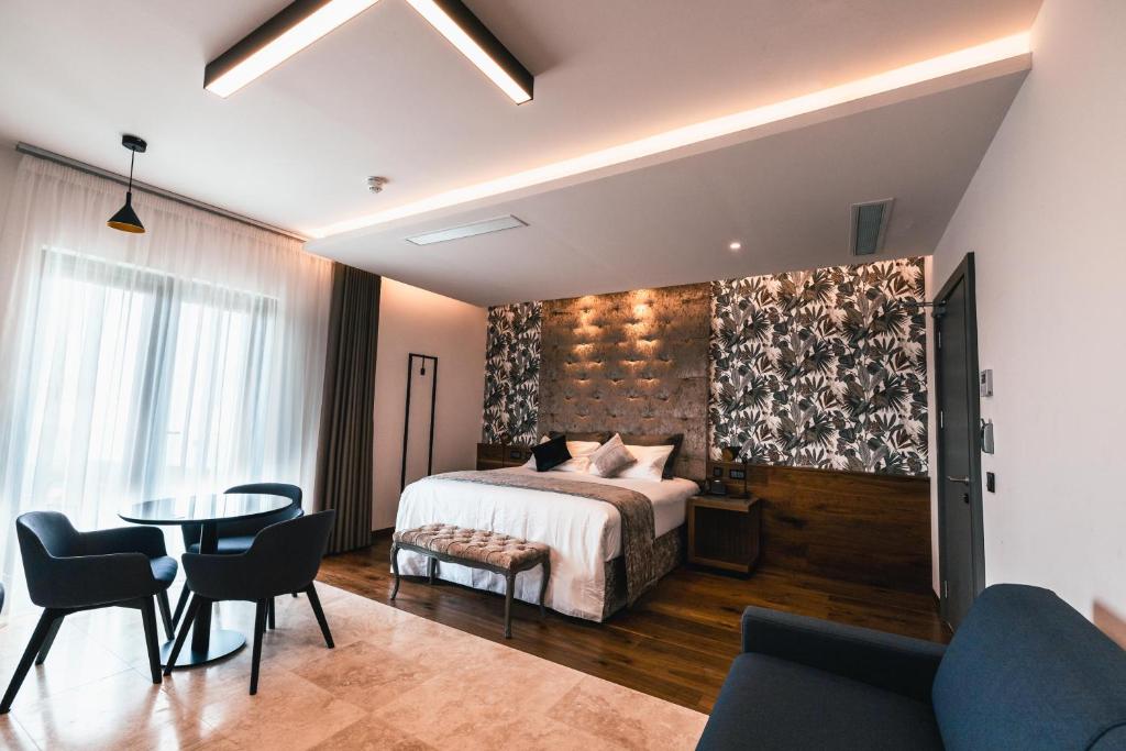 a bedroom with a bed and a table and chairs at The Village Boutique and SPA in Naxxar