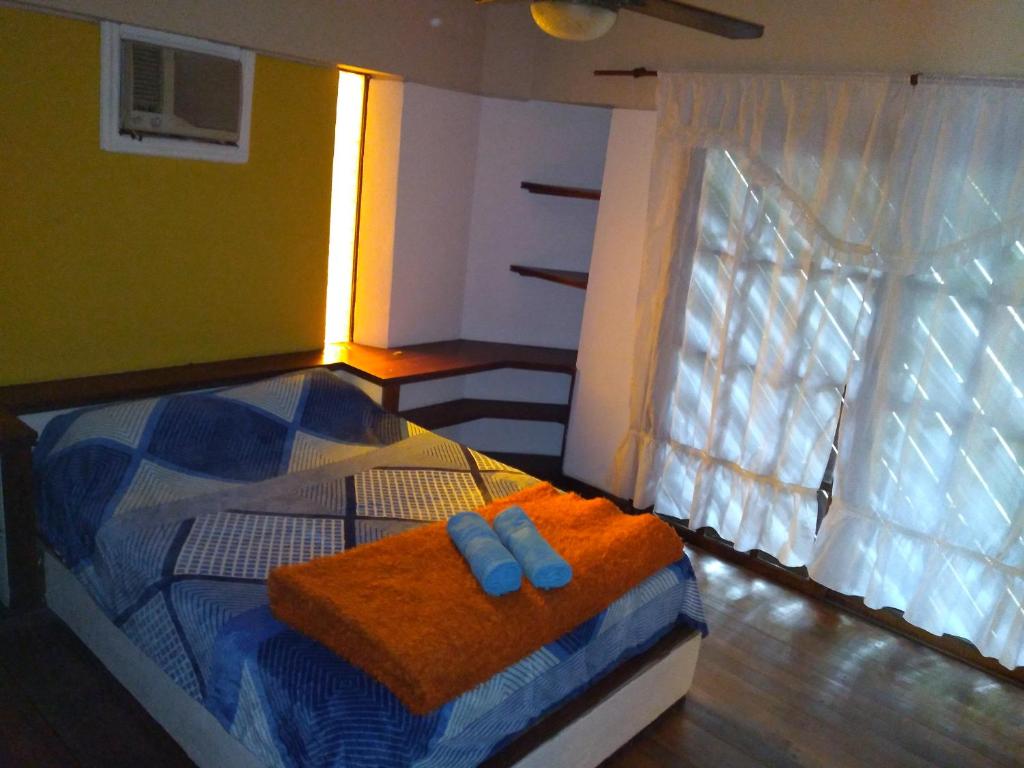um quarto com uma cama com duas toalhas azuis em T&A RESIDENCE Aeropuerto Ezeiza em Monte Grande