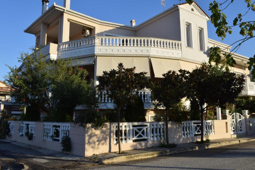 a large white house with a white fence at Five stars in Trikala in Tríkala