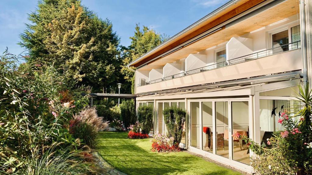 uma casa com um jardim em frente em ADORIS APPARTEMENTS im Lotzbeckpark am See "nachhaltiges Wohnen in Lindau" em Lindau