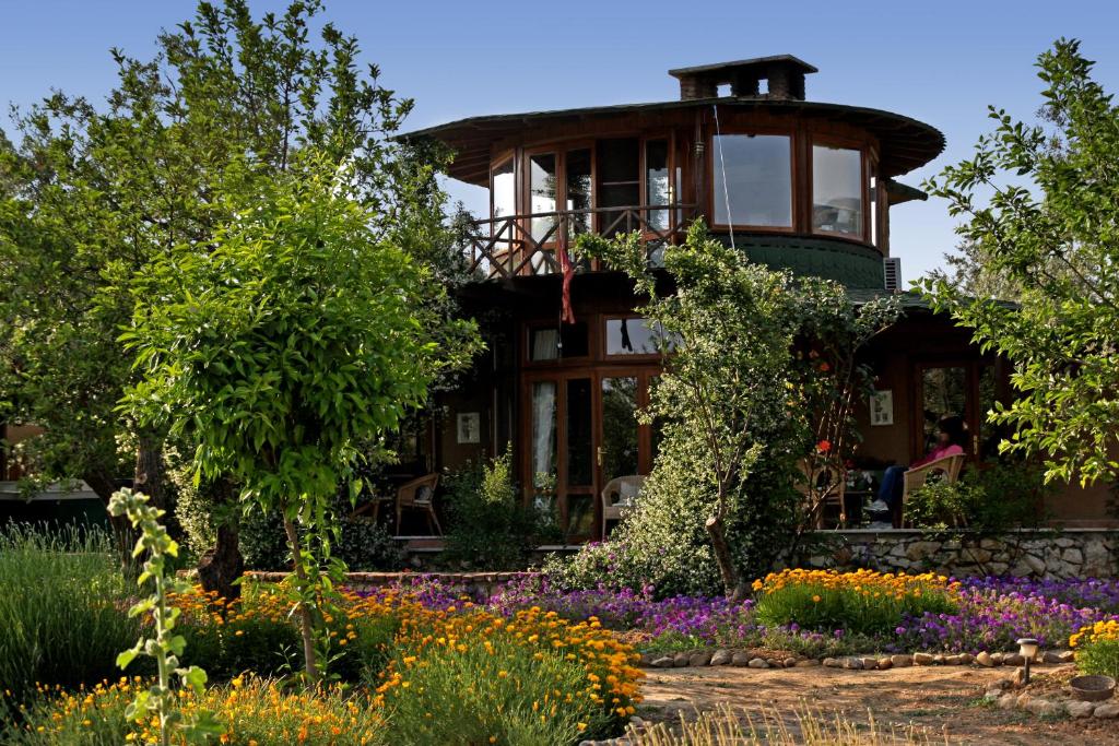 a house in the middle of a garden with flowers at Perfect Home with Private Beach by Iznik Lake in Bursa