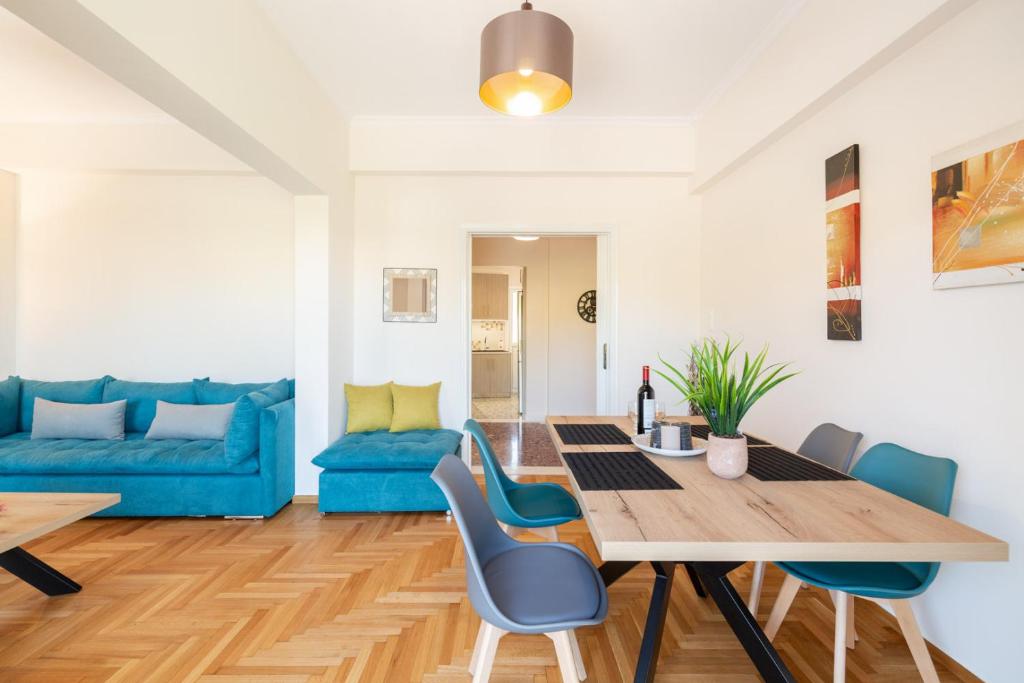 a living room with a wooden table and blue chairs at Katsanis luxury apt., stunning view of acropolis in Athens