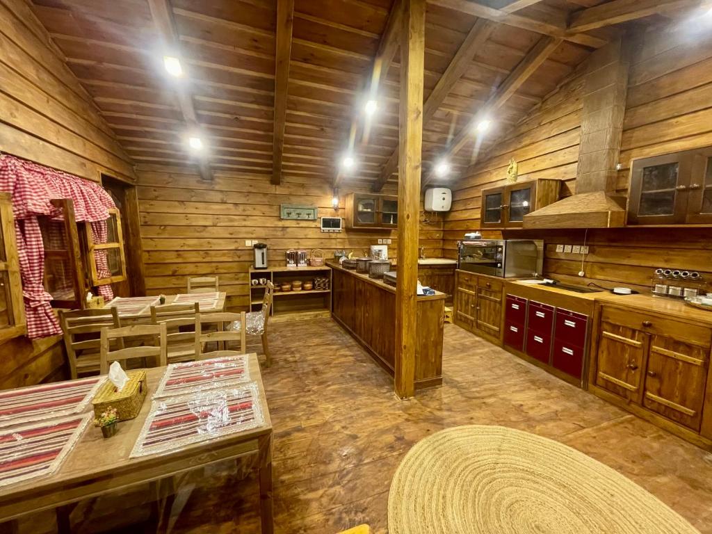 a large kitchen with wooden walls and wooden floors at نُزُل تُراثي شقْراء Heritage Guesthouse Shaqra in Shaqra