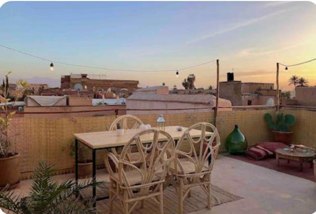 a patio with a table and chairs on a balcony at Riad Isabele in Old Medina in Marrakech