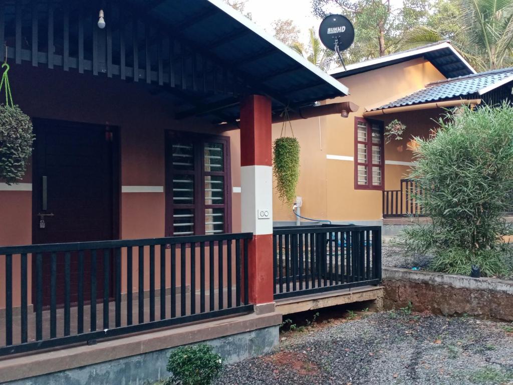 a house with a black and orange front porch at Wayanad Cocos Villa in Tariyod