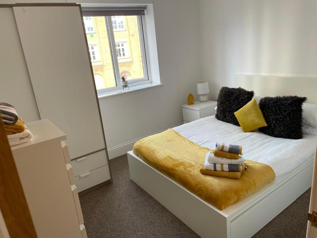 Central Hull Spacious Apartment H3 في هال: غرفة نوم بسرير ومرآة كبيرة