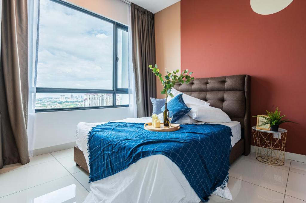 a bedroom with a bed with a blue blanket and a window at Sunway Pyramid View 3BR 2BR 2carpark in Petaling Jaya