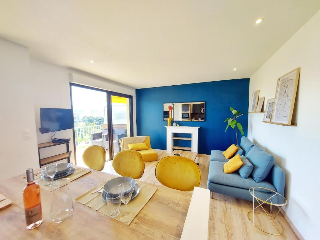 - un salon avec des murs bleus, un canapé et des chaises bleus dans l'établissement Appartement MARLENE - Lumineux - Terrasse - WIFI - Clim - Ajaccio, à Ajaccio