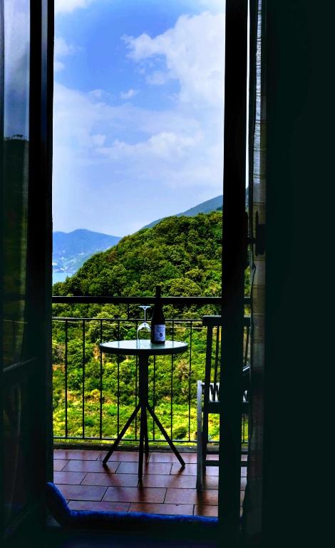 a table with a bottle of wine sitting on a balcony at il Magàn - Cinque Terre in Corniglia