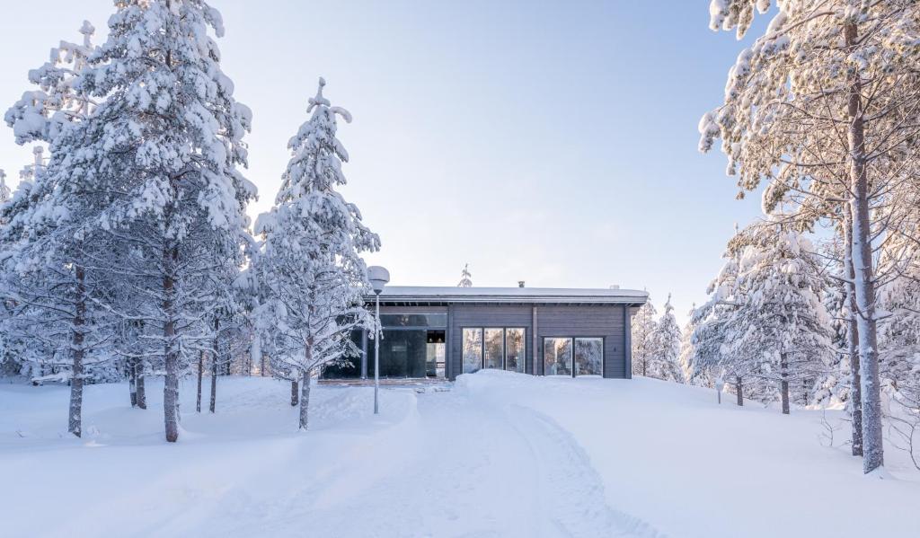 a house in the snow with trees in front of it at Rokovan Helmi - Natural peace in Ruka-Kuusamo in Ruka