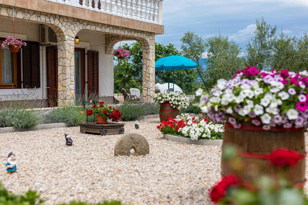 a garden with flowers and birds in front of a house at Apartment Dean in Klimno