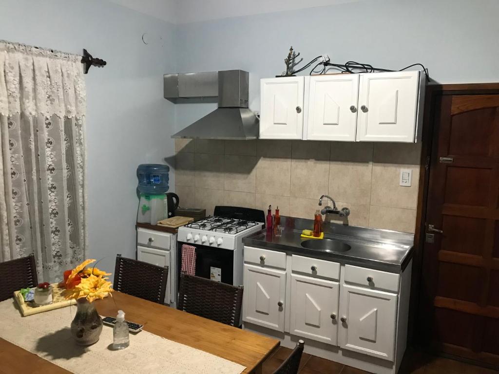 uma cozinha com armários brancos e um forno com placa de fogão em Lo de Annie Depto 2 em Posadas