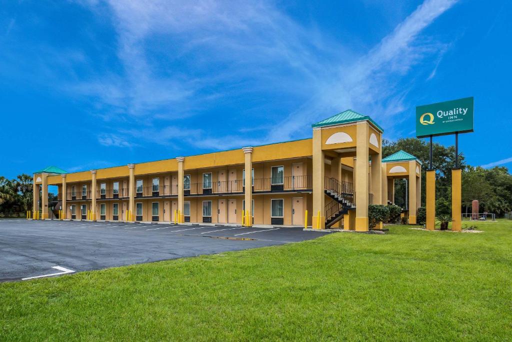 um grande edifício amarelo com estacionamento em Quality Inn White Springs Suwanee em Live Oak