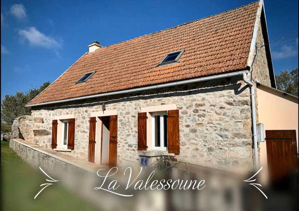 una pequeña casa de piedra con techo rojo en Maison de vacances La Valessoune en Valessard