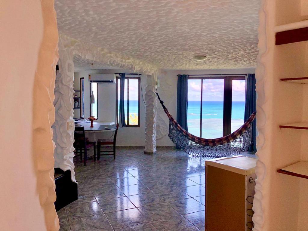 a living room with a hammock in the middle of the room at Suítes Bela Vista in Japaratinga