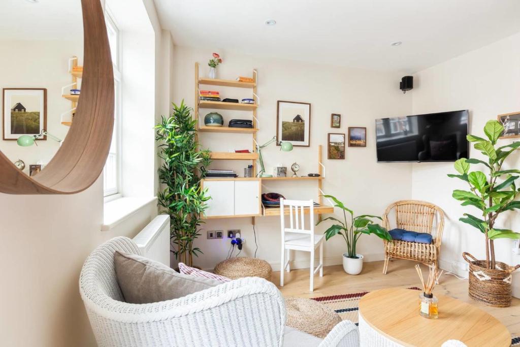 una sala de estar con muebles blancos y plantas en Large Luxury Studio in Heart of Richmond, en Richmond