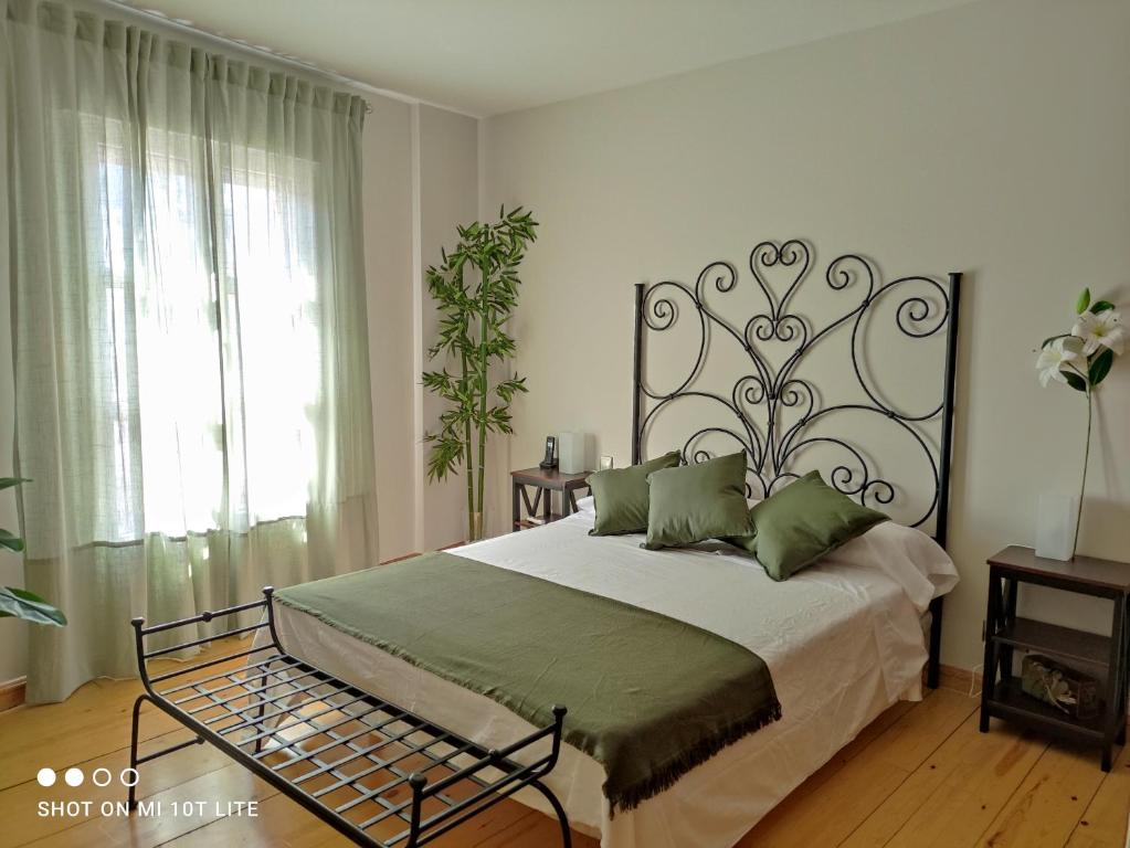 a bedroom with a large bed with a wrought iron headboard at Rucanon 1 La casa del pueblo 4 Estrellas in Montánchez
