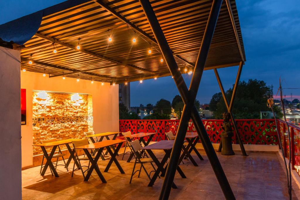 a patio with tables and chairs under a pergola at Hostal Talavera in Puebla