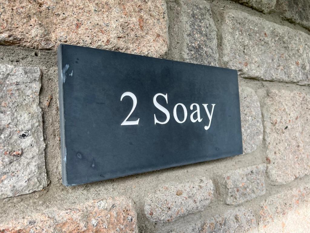 蒂恩格的住宿－Soay@Knock View Apartments, Sleat, Isle of Skye，一块砖墙上的 ⁇ 音