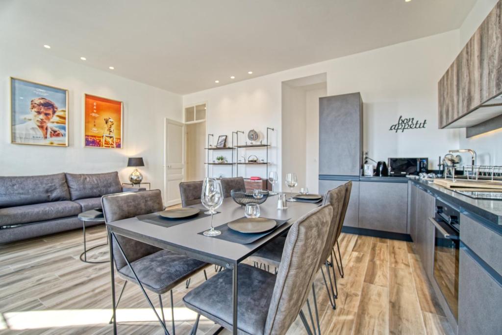 a kitchen and living room with a table and chairs at Superbe 3 pièces refait à neuf classé 4 étoiles avec ascenseur et balcon à pied de la plage et du palais des festivals in Cannes