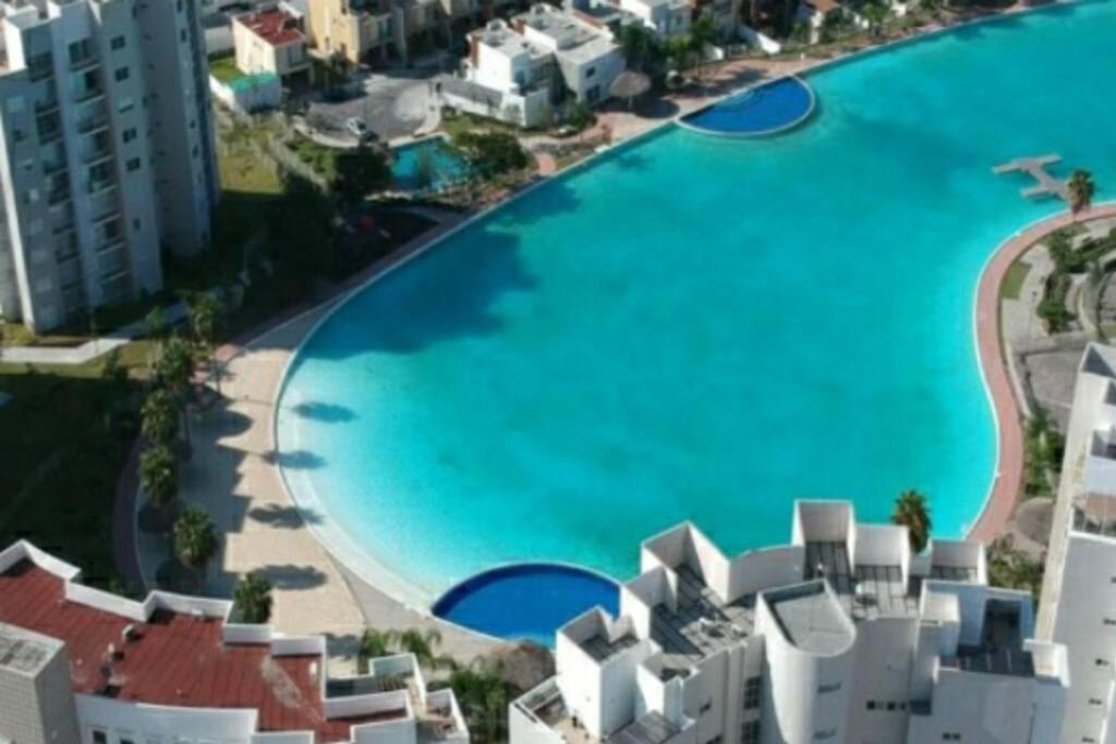 an overhead view of a large swimming pool next to buildings at Increible Apartment with beach Monterrey/Apodaca in Monterrey