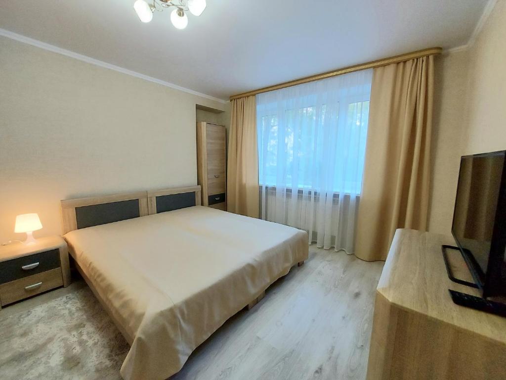 a bedroom with a large bed and a large window at Апартаменты возле Зоопарка in Kaliningrad