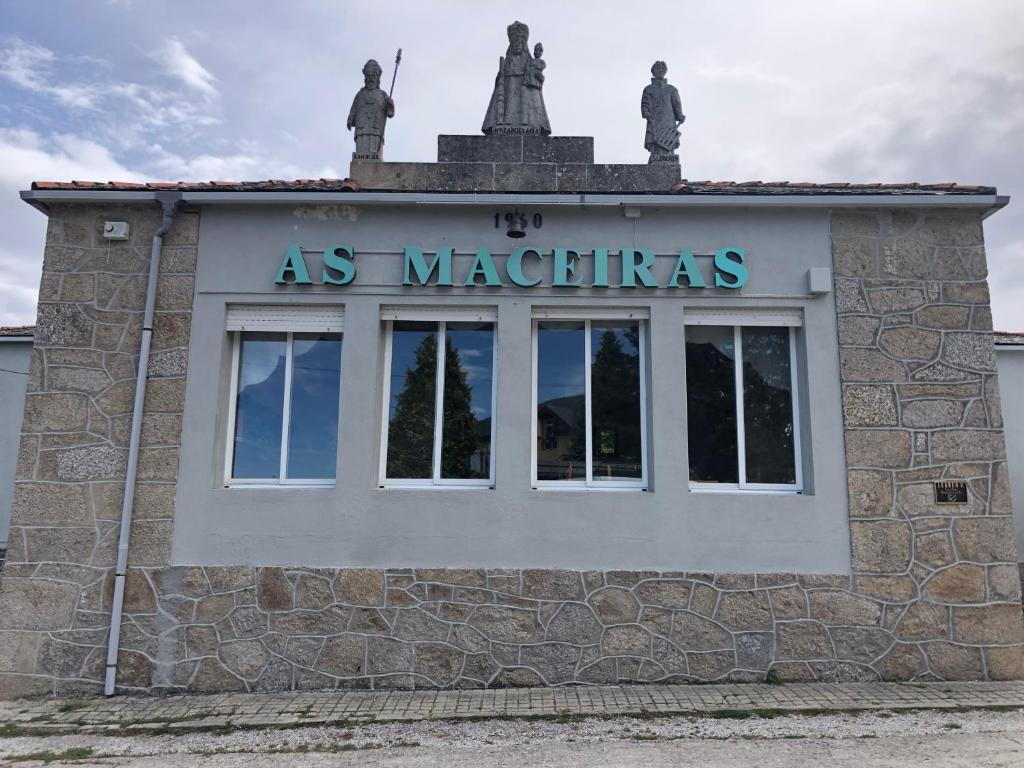 a building with two statues on top of it at HOTEL AS MACEIRAS in Trives