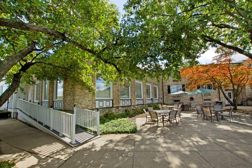 eine Terrasse mit Tischen und Stühlen vor einem Gebäude in der Unterkunft Penn Harris Hotel Harrisburg, Trademark by Wyndham in Harrisburg