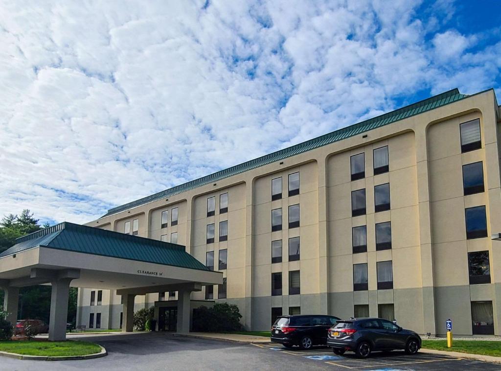 a large building with two cars parked in a parking lot at Comfort Inn Saco - Old Orchard Beach in Saco