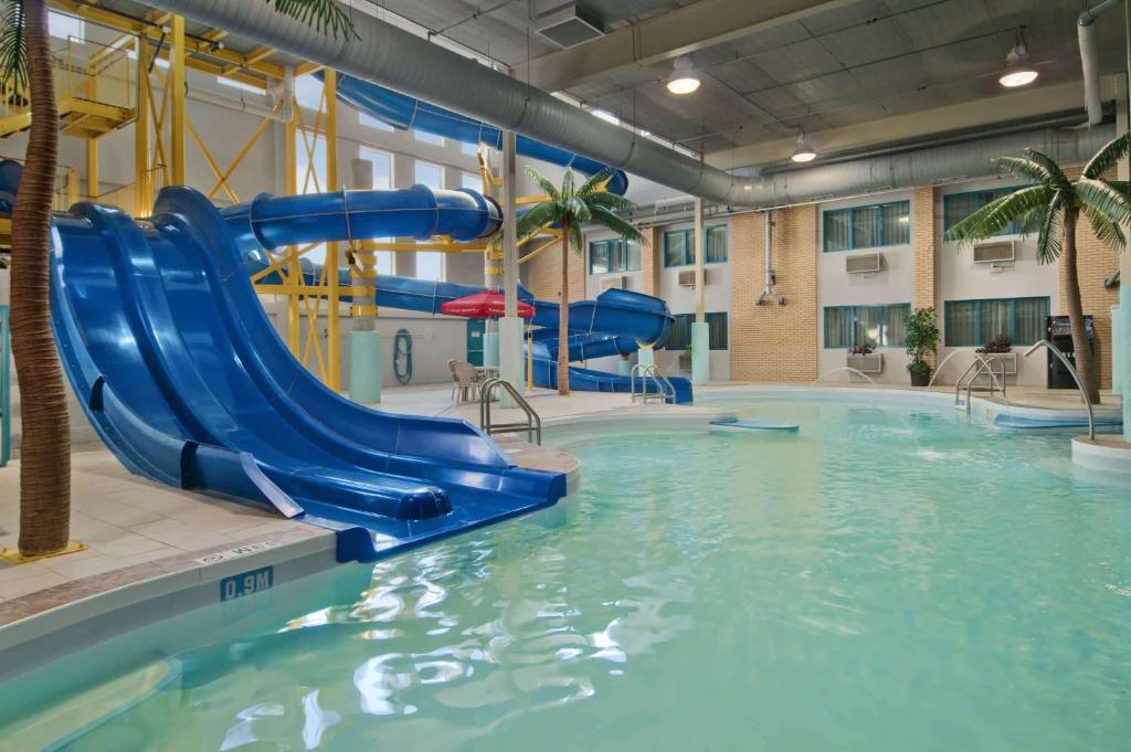 a pool with a water slide in a building at Travelodge by Wyndham Winnipeg in Winnipeg