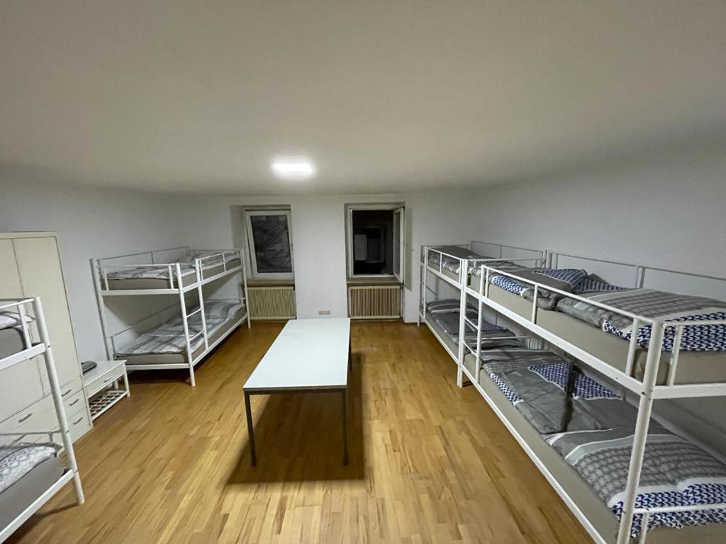 a room with four bunk beds and a table at Schlaffburg in Klosterneuburg