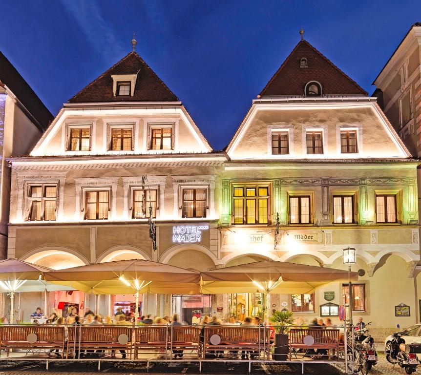 un gran edificio con mesas y sillas delante de él en Hotel Mader en Steyr