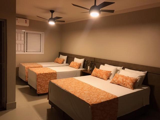 - une chambre avec 2 lits et un ventilateur de plafond dans l'établissement POUSADA MALA E CUIA, à Rifaina