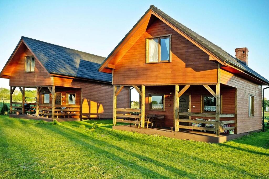 una gran casa de madera en un campo verde en Holiday homes for 7 people in winouj cie, en Karsibór