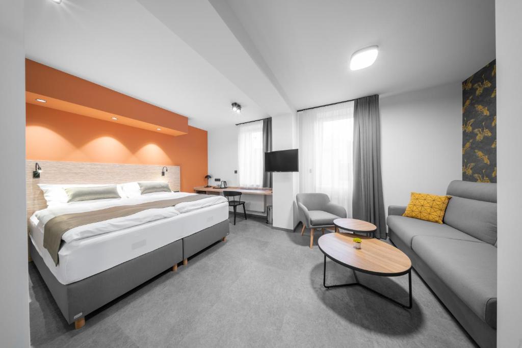 een hotelkamer met een bed en een bank bij Hotel Diana in Karviná