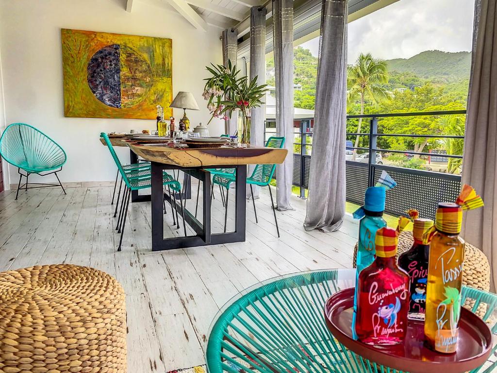 a room with a table and chairs and a balcony at Acacia Secret, 3 min walk from Anse Marcel beach, on the Marina in Anse Marcel 