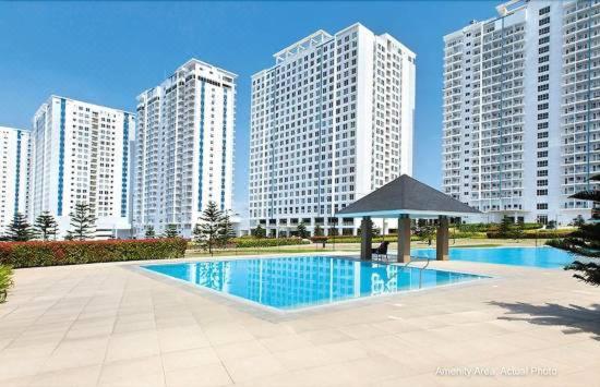 uma piscina numa cidade com edifícios altos em EMSMAR 908 Wind Residences Tagaytay em Tagaytay