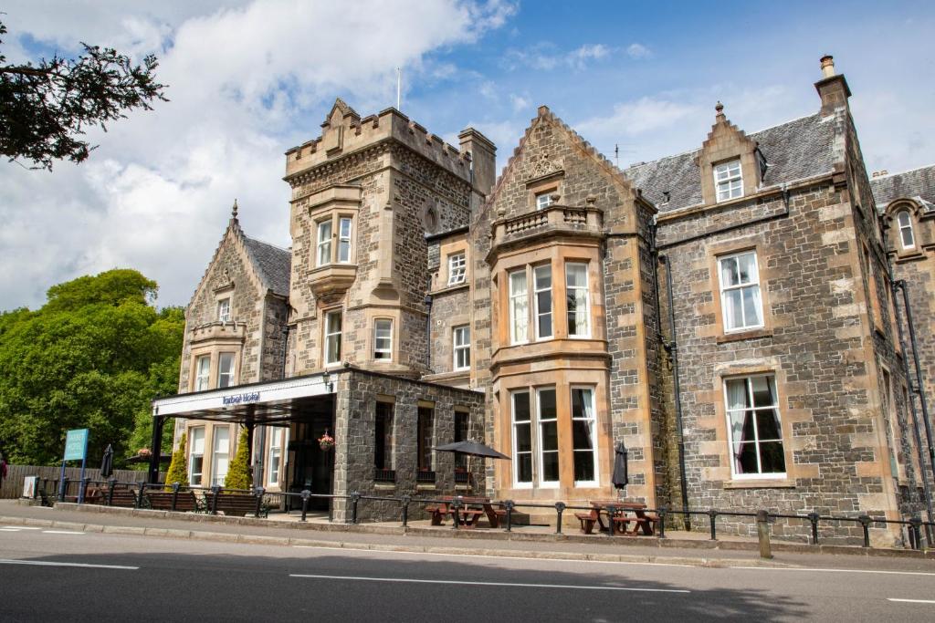 an old stone building on the side of a street at The Tarbet Hotel in Tarbet