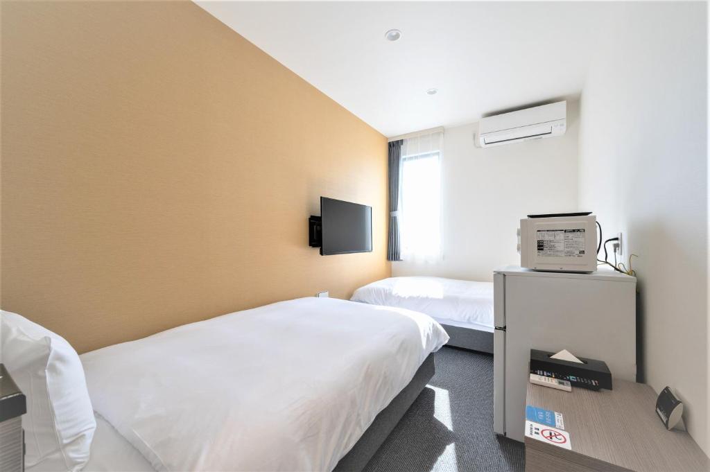 Postel nebo postele na pokoji v ubytování HOTEL R9 The Yard Hitachinaka