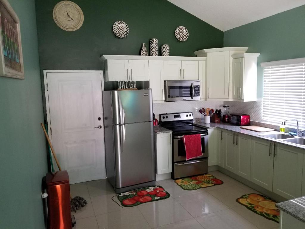 una cucina con frigorifero in acciaio inossidabile e armadietti bianchi di A PLACE LIKE HOME a Hartford
