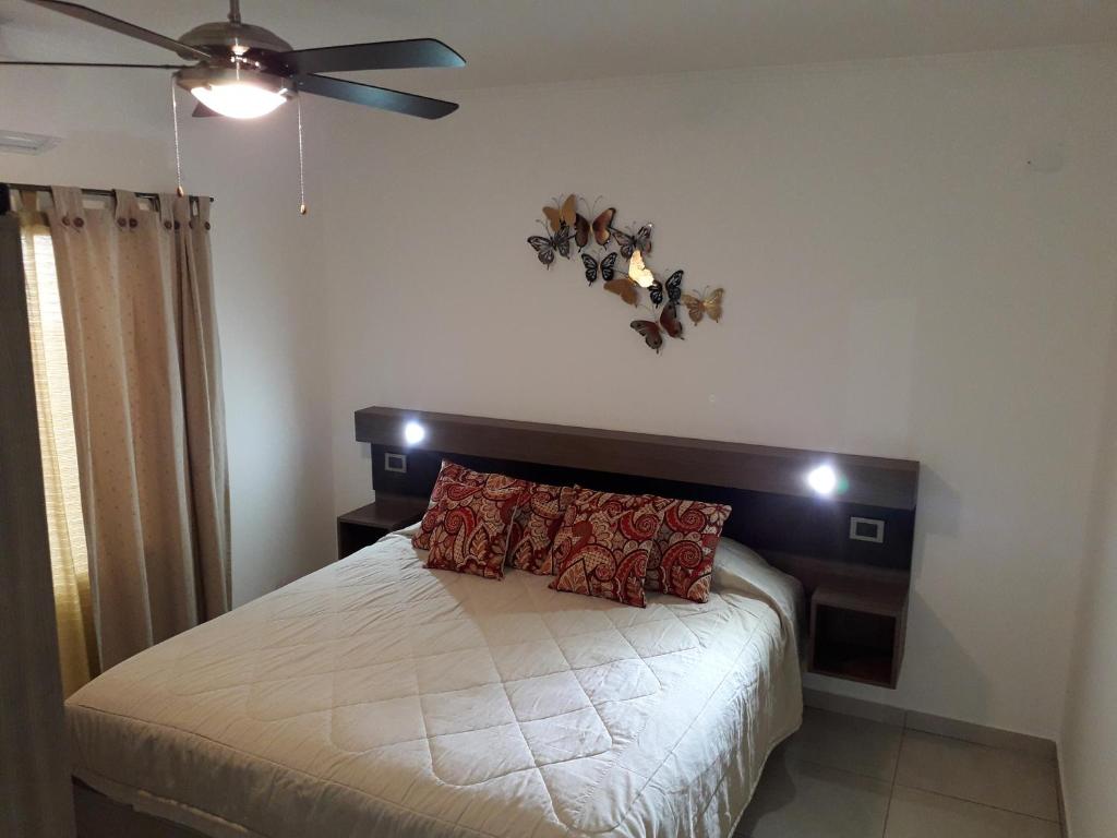 een slaapkamer met een bed en een plafondventilator bij Punto Termal - Depto 8 in Federación